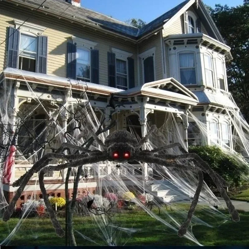 Large spider decoration in front of a house with Halloween decorations