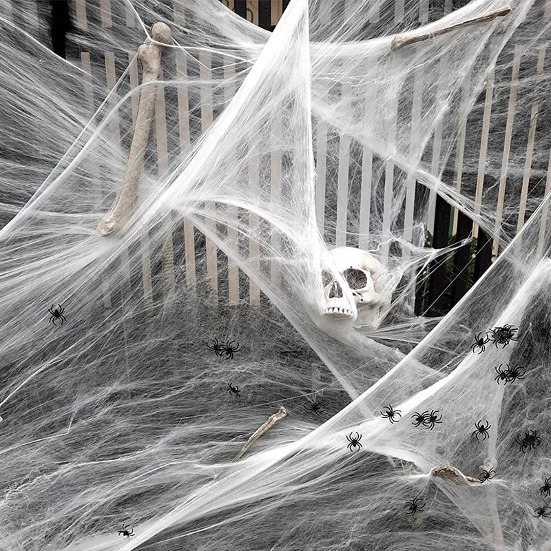 Halloween decoration with spider webs, a skull, and spiders on a staircase.