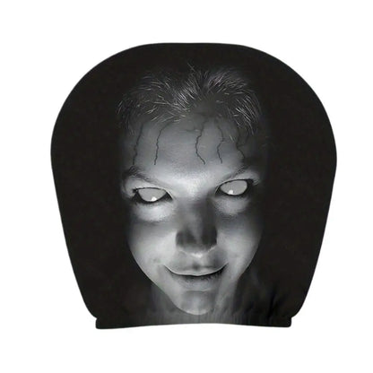 A black novelty headrest or pillow featuring a high-contrast black and white graphic print of a creepy face with glowing white eyes and cracks on the forehead, shown against a plain white background.