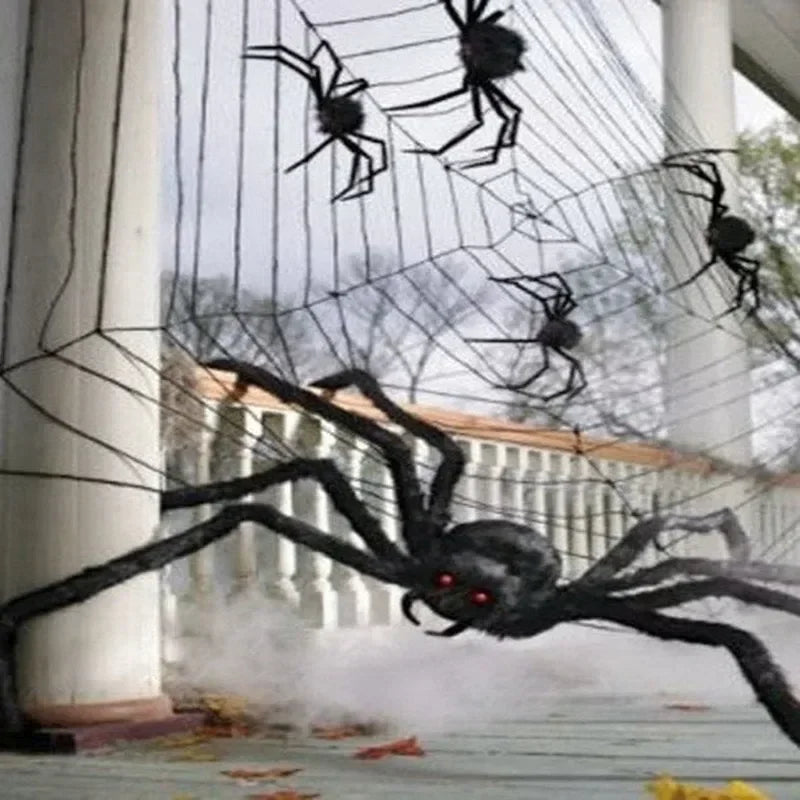 Halloween spider decorations on a web with a house in the background