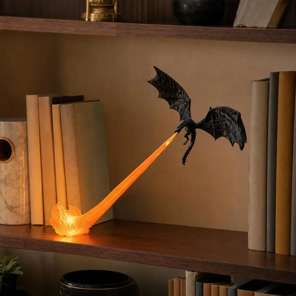 A black dragon figurine casting a bright orange beam of light, placed on a wooden bookshelf between books in a warm indoor setting.