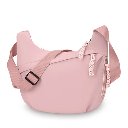 Pink crossbody bag with a strap on a white background