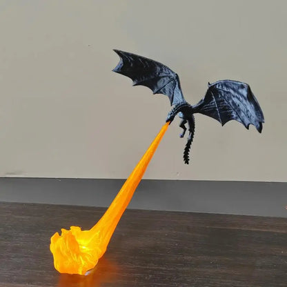 Black dragon toy with orange flame on a wooden surface