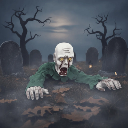 A Halloween-style zombie prop crawling out of a foggy graveyard at night, wearing a green shirt and reaching toward the viewer with yellow glowing eyes.
