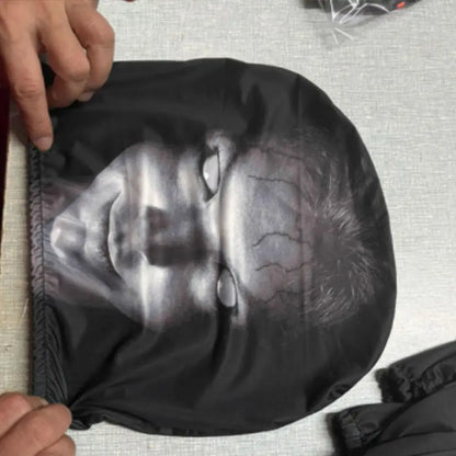 Black swim cap with a graphic of a face on a textured surface